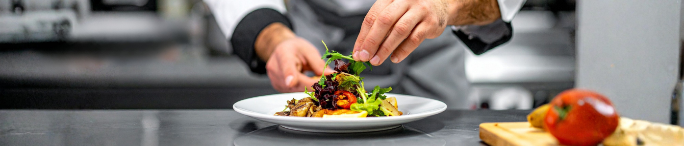 mains de cuisinier qui dresse une assiette
