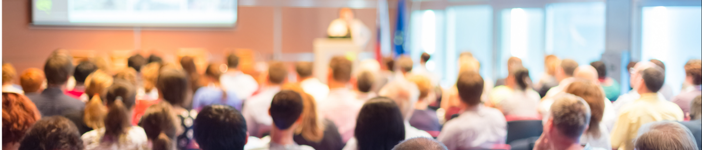 Participants assistant à une conférence dans une salle de réunion avec écran de présentation