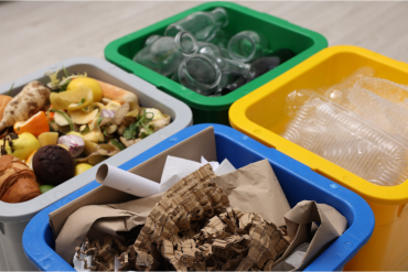 Bacs de tri contenant des déchets alimentaires, des bouteilles en verre, des emballages en plastique et du papier-carton.